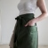 Dark green washed linen half apron with adjustable width and a pocket